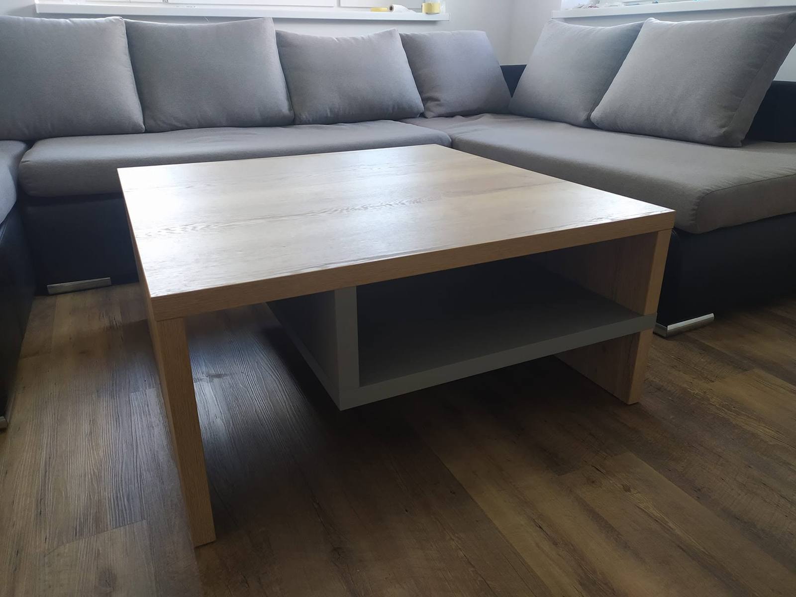 Großer Eichen-Couchtisch mit weißem Bord vor dem Sofa