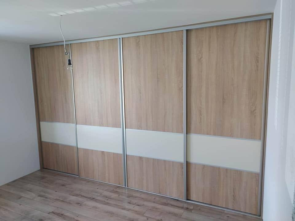 Viertüriger Kasten in Eiche-Dekor mit cremefarbenem Band über die Wand