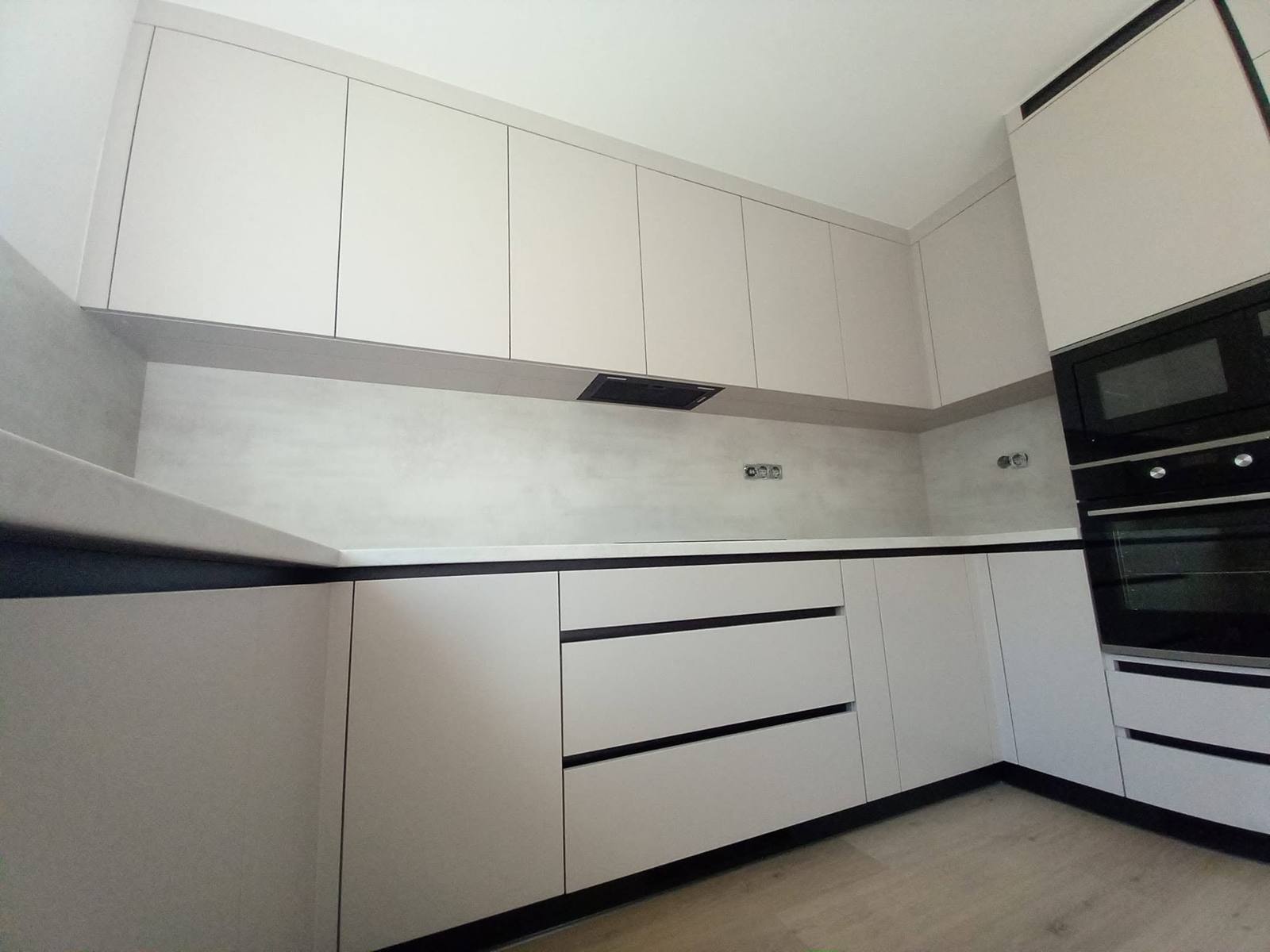 Deckenhohe Hängekästen und Hochschrank mit schwarzen Einbaugeräten