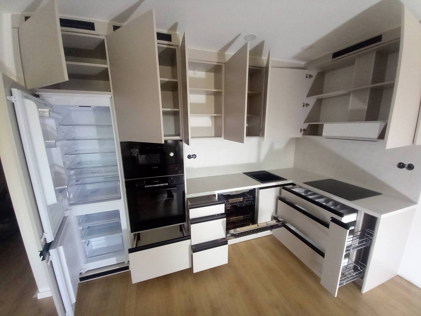 L-Küche mit geöffneten Hängekästen, Laden und Kühlschrank