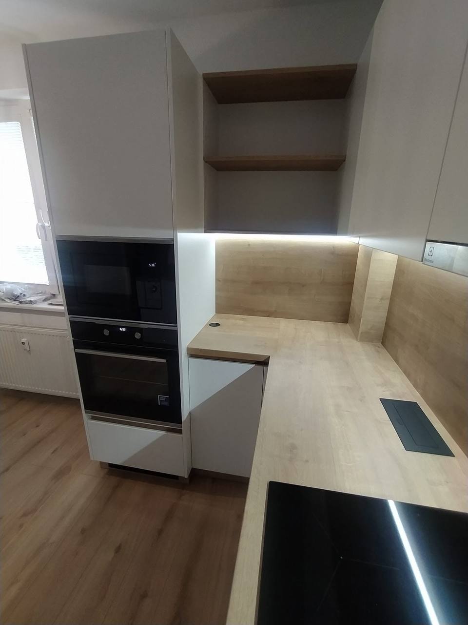 Hochschrank mit Mikrowelle und Backrohr neben der Eichenplatte