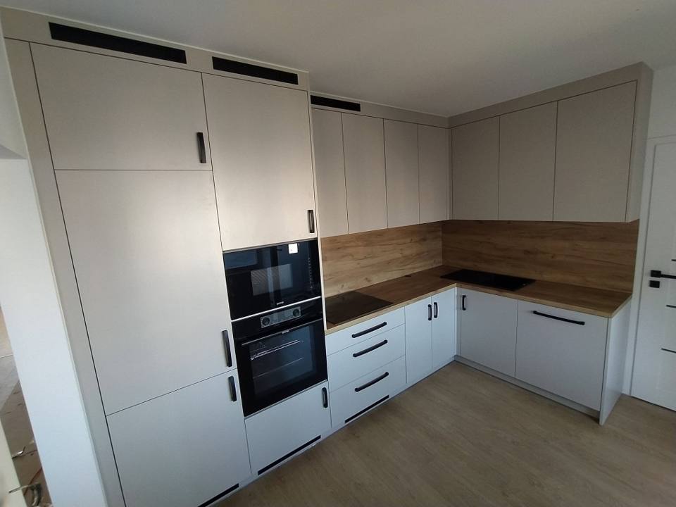Helle Küche mit Eichendekor und hohem Schrank mit Backrohr