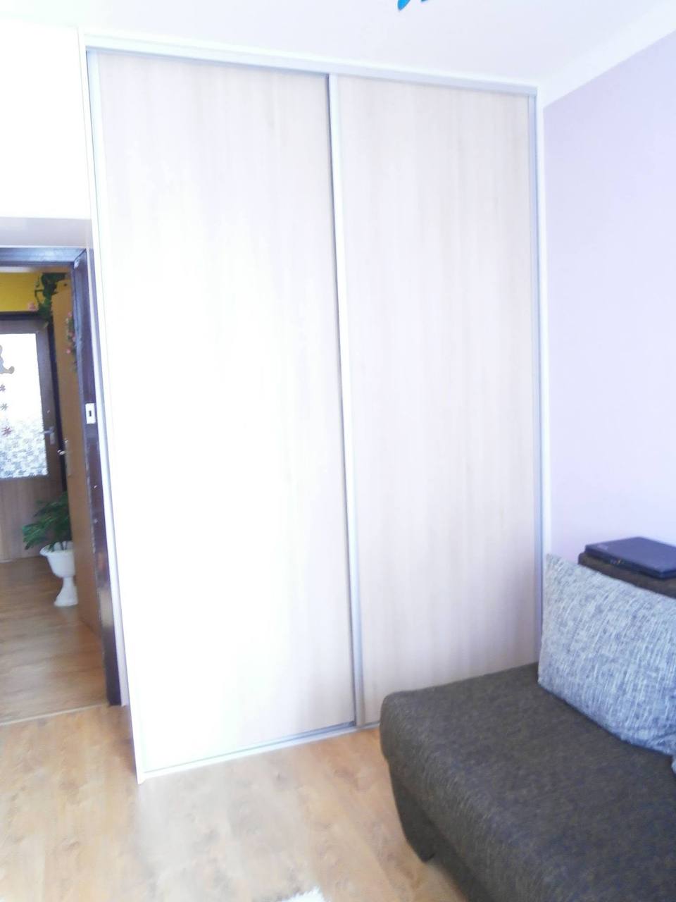 Heller zweitüriger Schiebetürenkasten im Wohnzimmer mit Couch