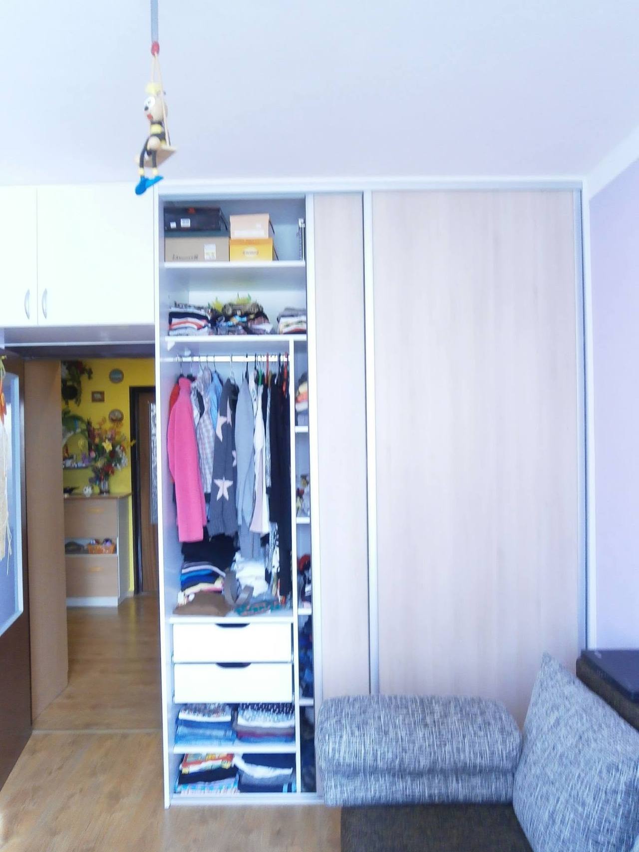 Offener Kasten mit Fachböden, Stange und Laden neben der Couch
