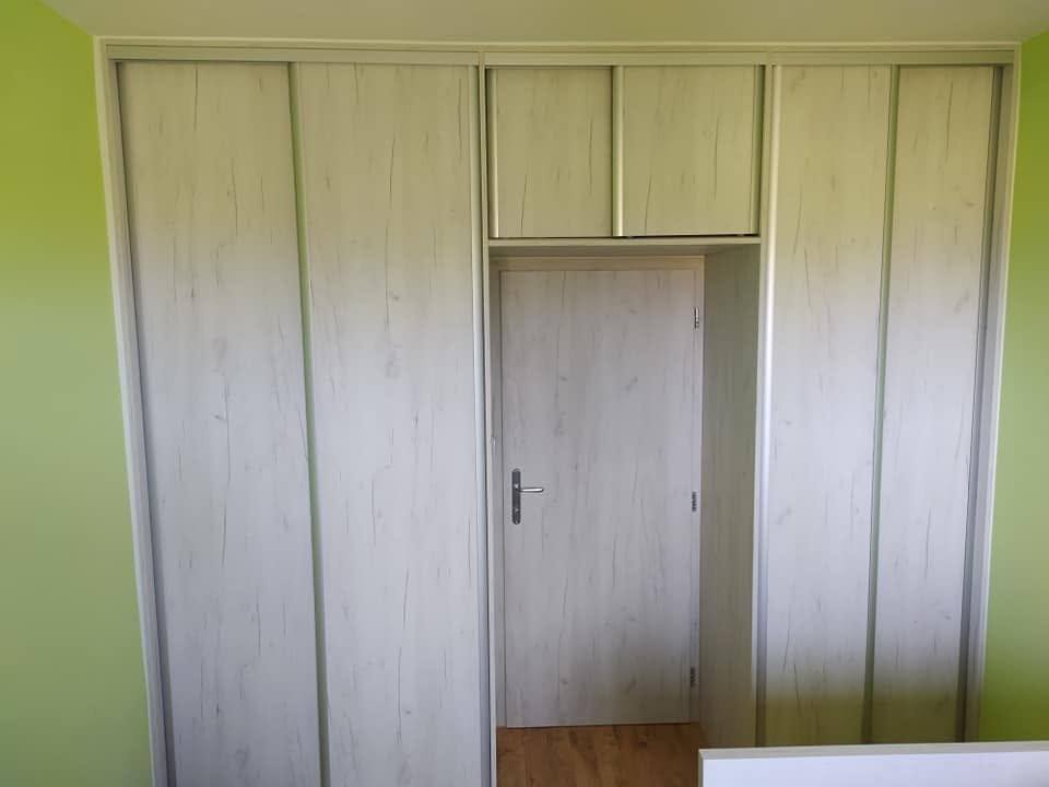 Helle Kastenwand rund um die Tür vor der grünen Wand