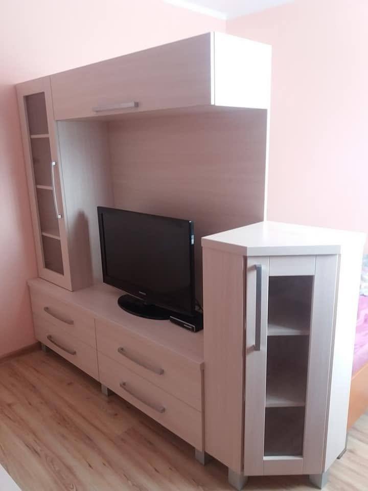 Helle TV-Wand mit Eckvitrine und Aufsatz über dem Fernseher
