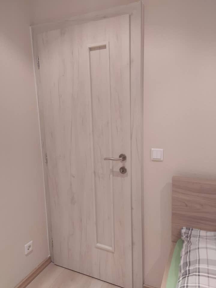 Helle Tür in gebleichter Eiche mit vertikaler Rille beim Schlafzimmer.