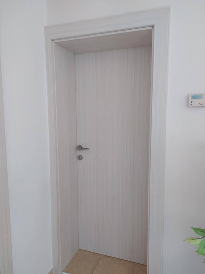 Helle Innentür in gebleichtem Dekor im weißen Flur der Wohnung.