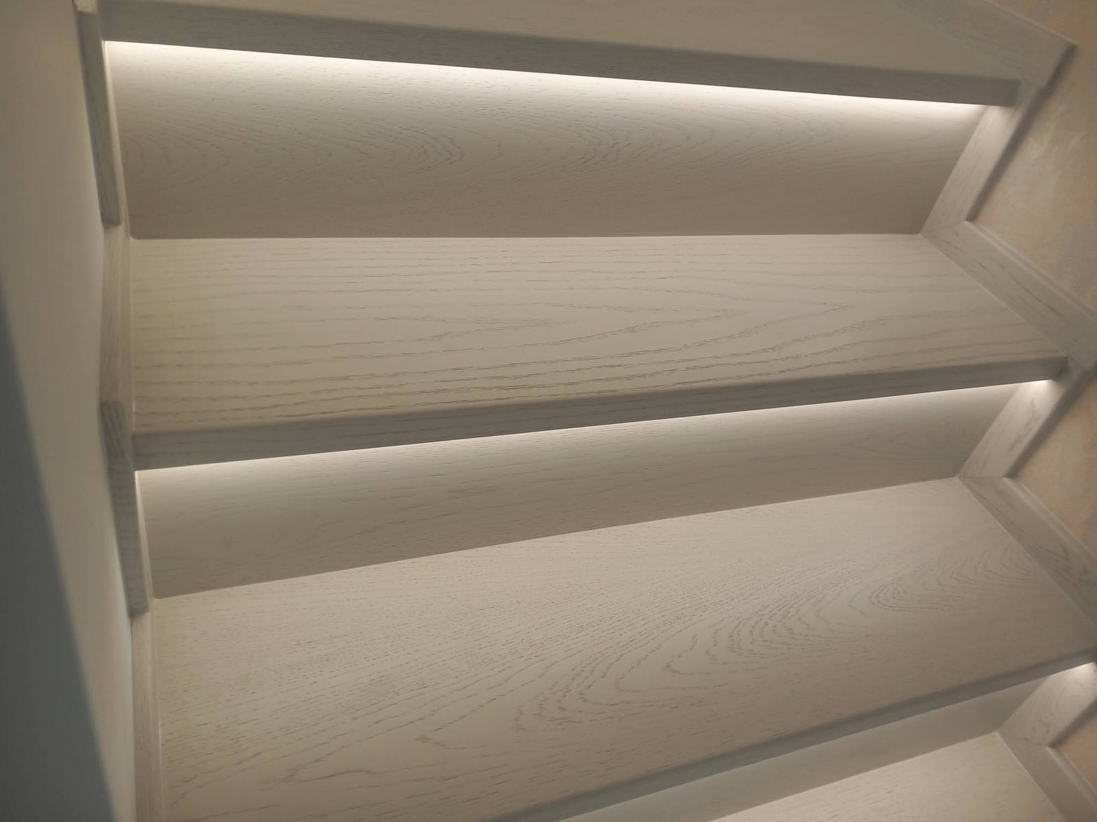 Detail des LED-Bands unter der Kante der hellen Eichenstufe