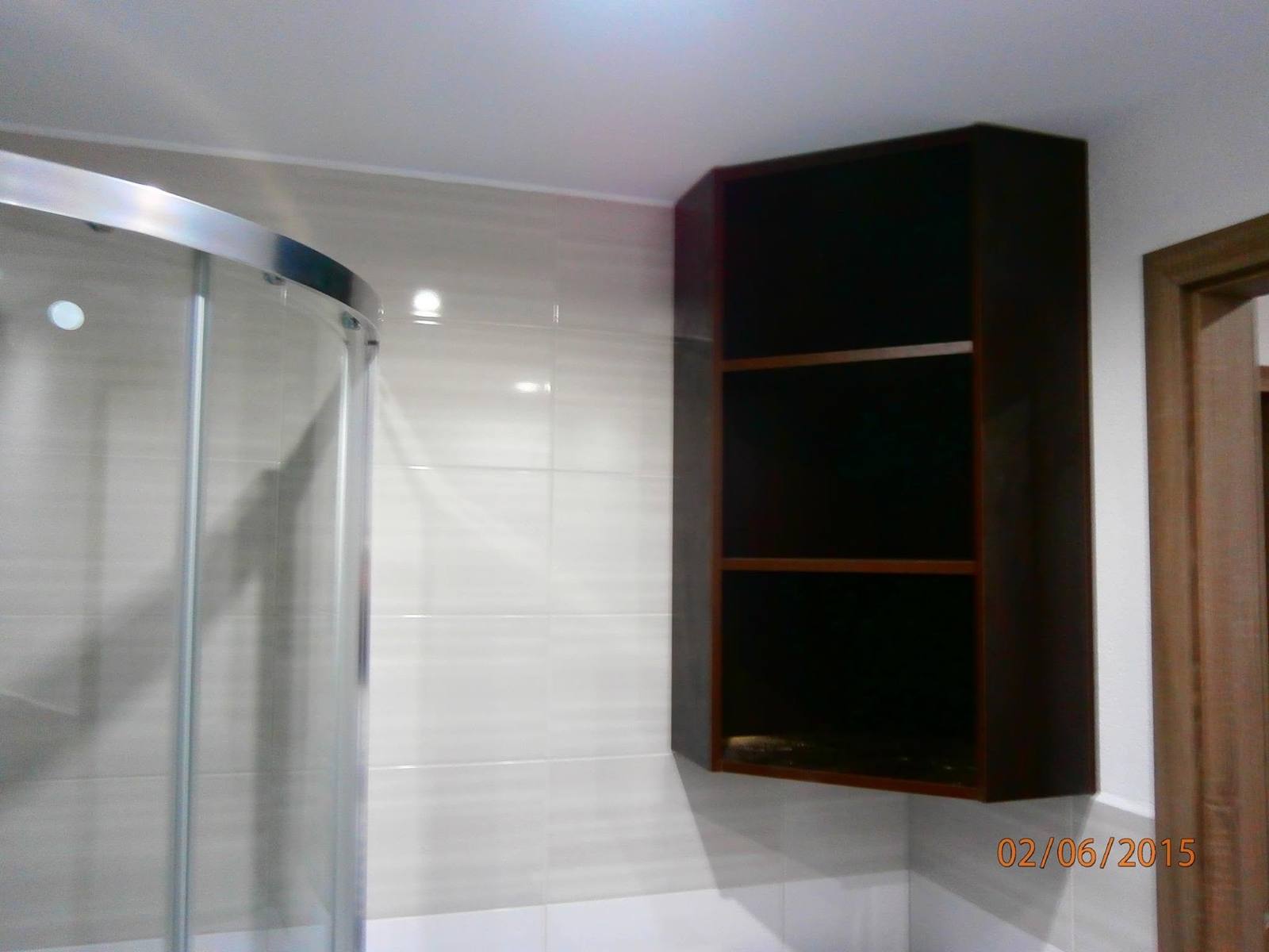Wenge-Regal beim Eingang zur runden Glasdusche im Bad