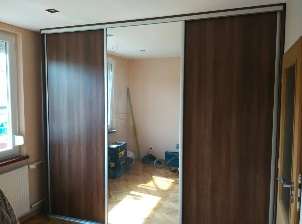 Dunkler Nussbaumkasten mit Spiegel am Fenster