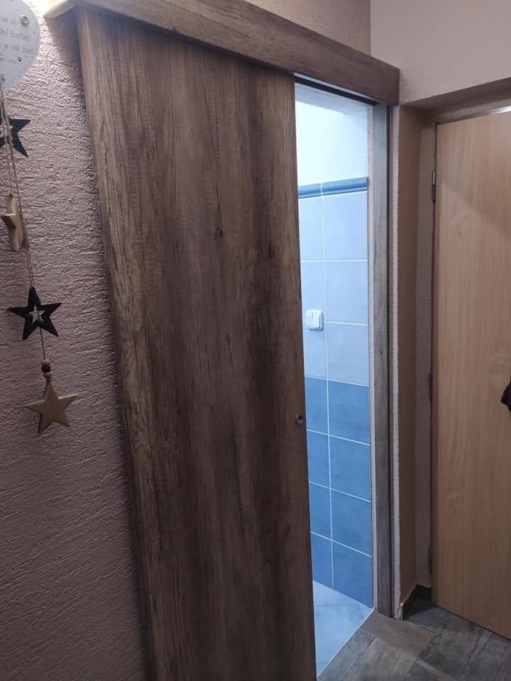 Schiebetür in dunkler Eiche an der Wand beim Bad