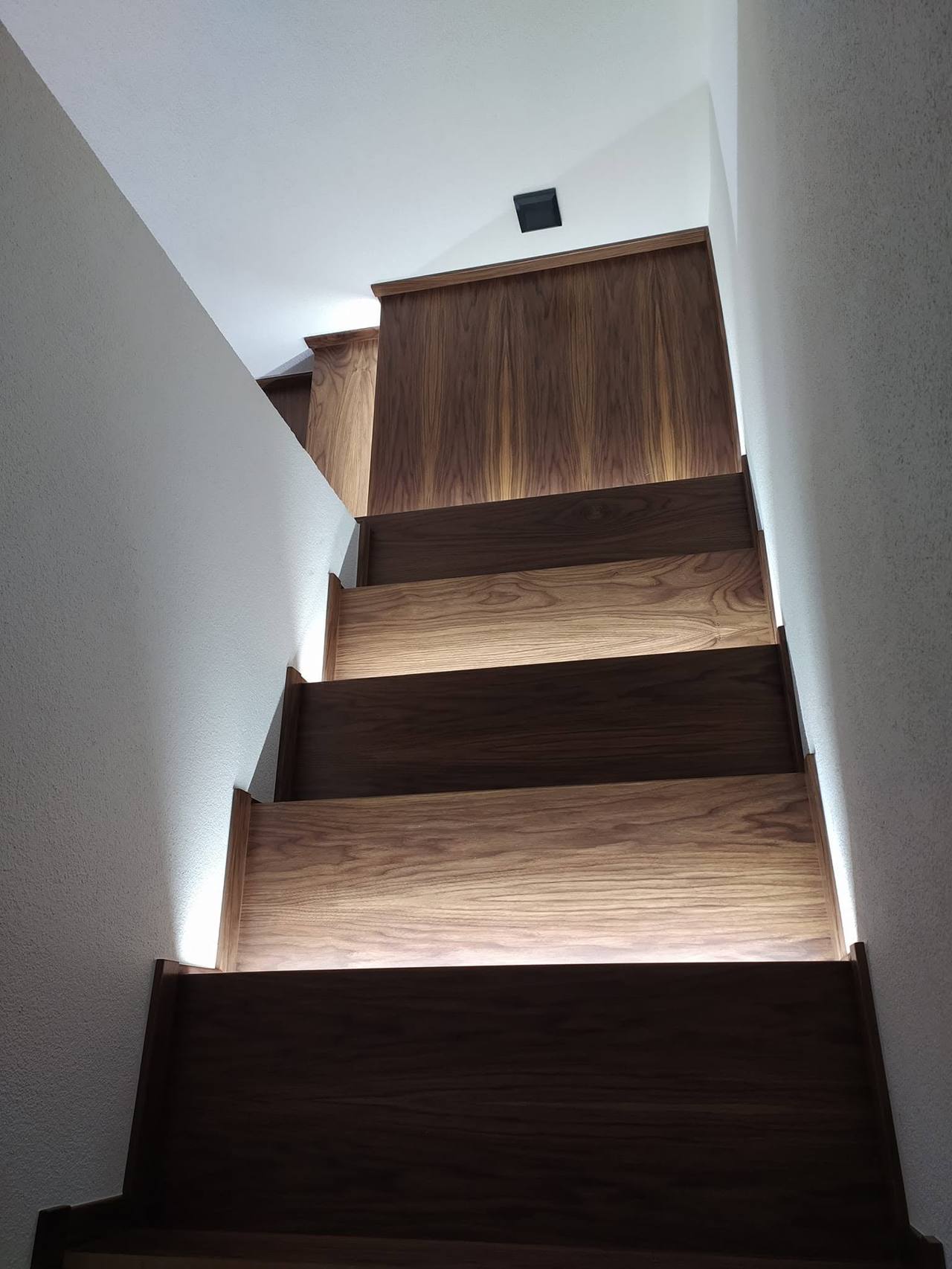 Dunkle Stiege mit LED-Licht und weißen Wänden
