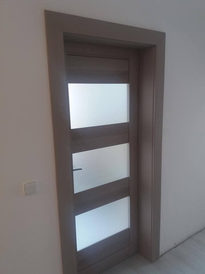 Dunkle Tür mit drei Glasfeldern aus leicht seitlicher Ansicht