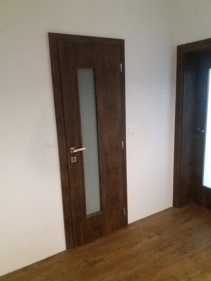 Dunkle Innentür in Nussbaumdekor mit schmalem Milchglasstreifen.