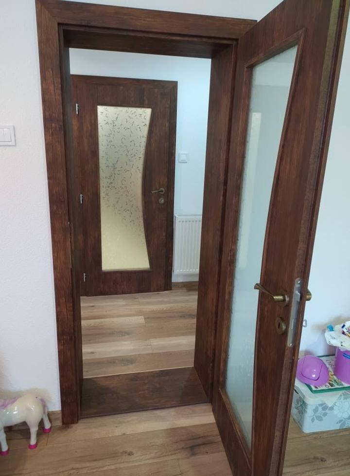 Geöffnete dunkle Tür mit Blick auf eine weitere Glastür