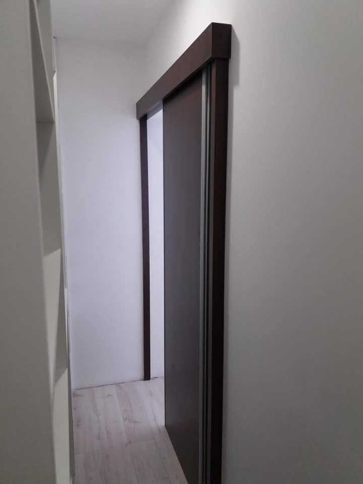 Dunkle Schiebetür in Wenge-Optik im schmalen Flur