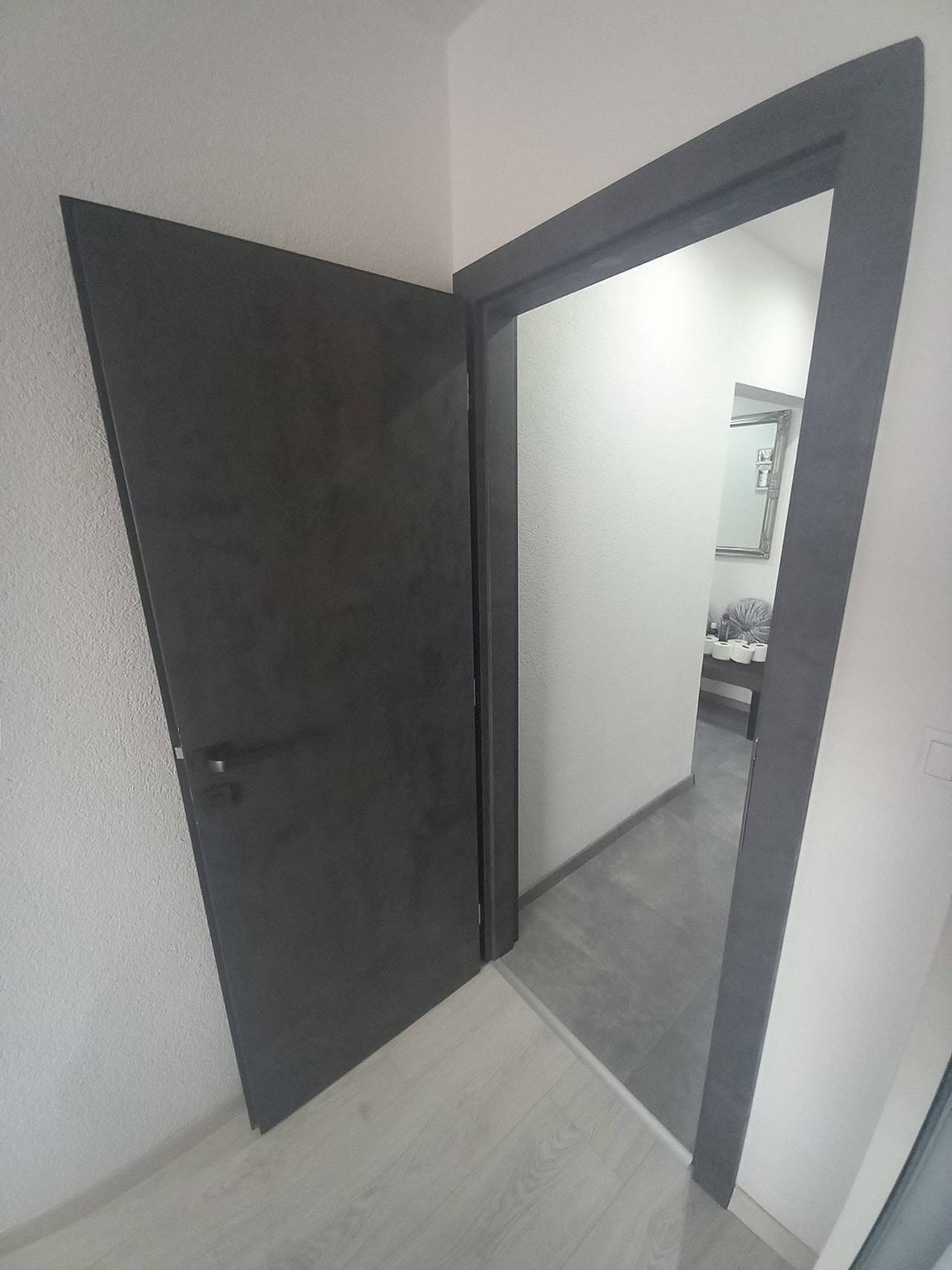 Dunkelgraue Tür mit Aluminiumrahmen geöffnet zum Flur