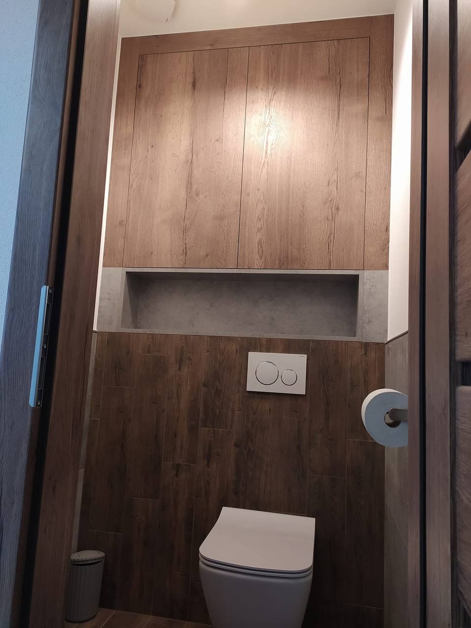 WC mit Vorwandverkleidung in dunkler Eiche und beleuchteter Nische