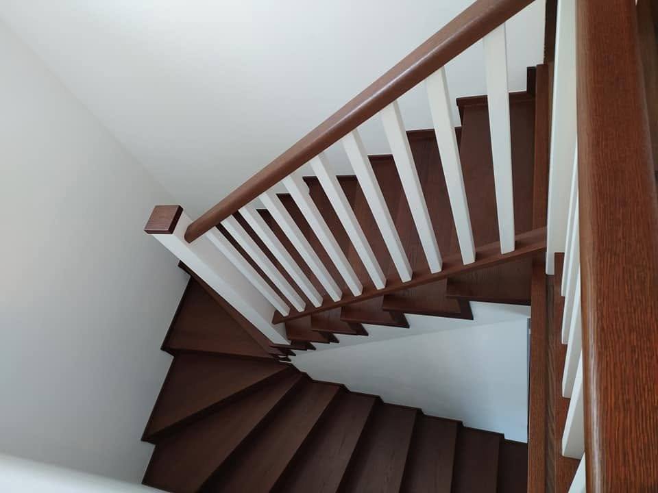 Točité schodisko so zábradlím s bielymi stĺpikmi z bočnej strany