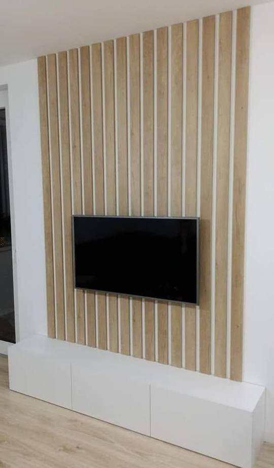 Lamellenverkleidung mit Fernseher und weißem Lowboard von der Seite