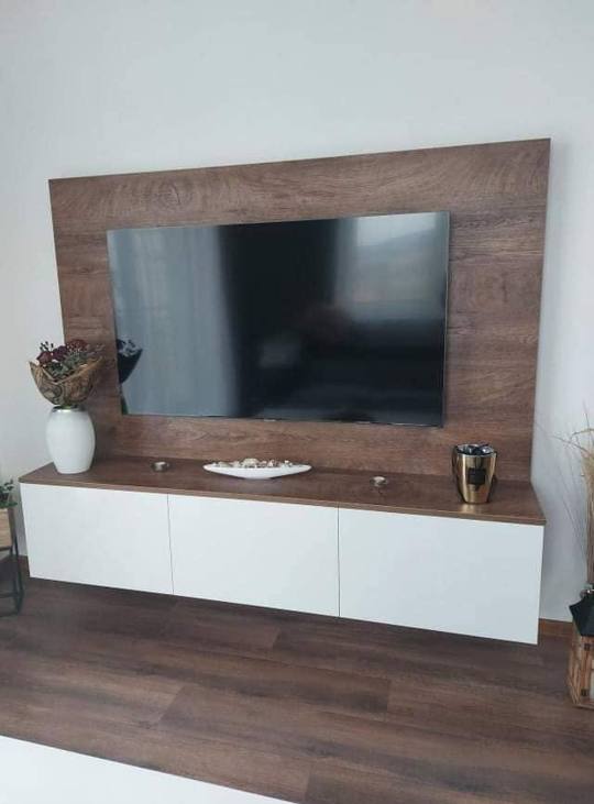 Frontansicht der TV-Wand mit Paneel und weißem Lowboard