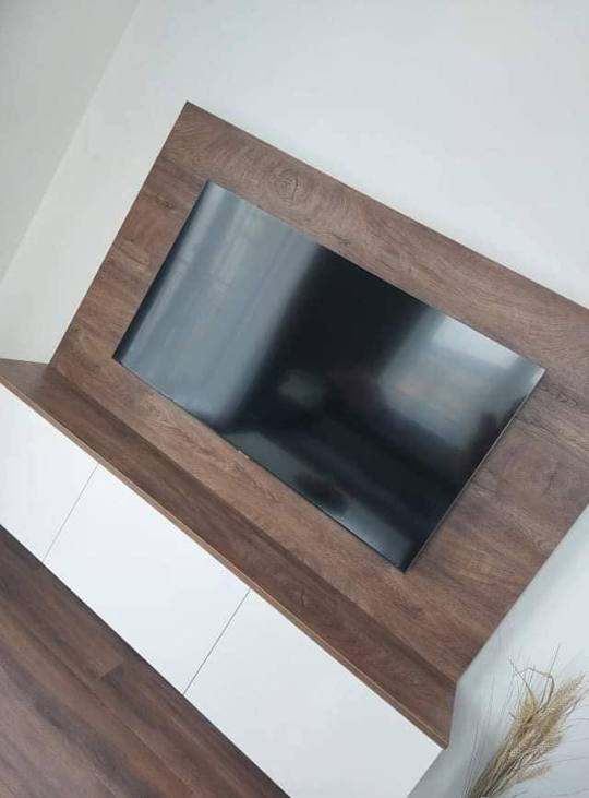 Seitenansicht des TV-Paneels in dunkler Holzoptik und des Lowboards