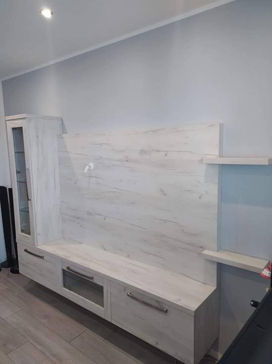 Seitenansicht der TV-Wand mit Vitrine und Borden rechts