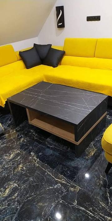 Couchtisch in schwarzer Marmoroptik vor dem gelben Ecksofa