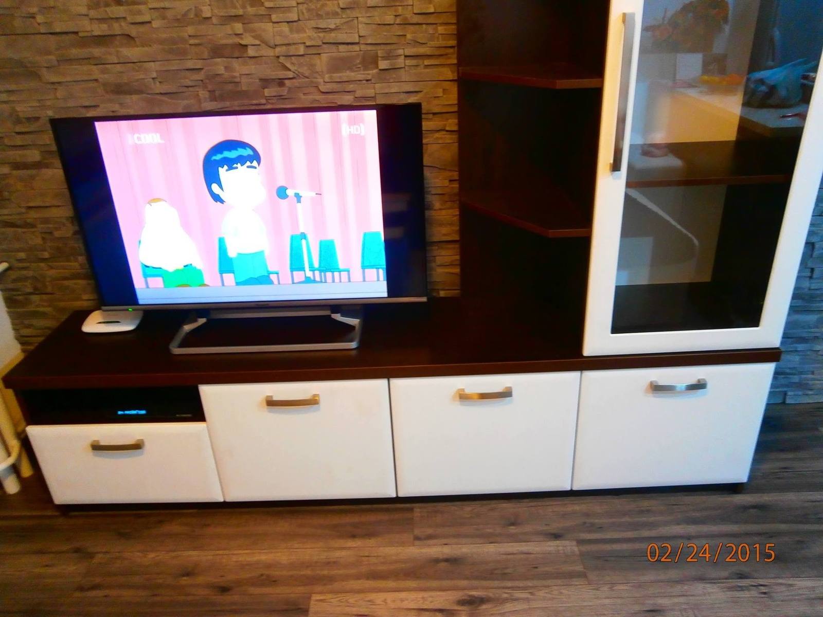 Weißes TV-Möbel mit Vitrine und dunklen Borden