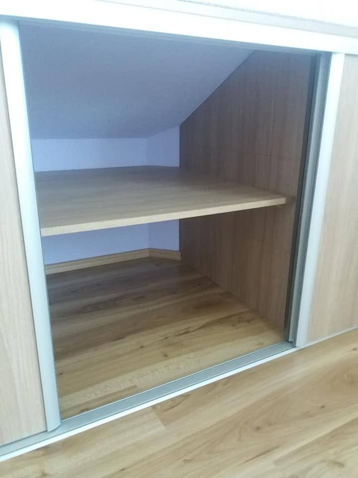 Blick durch die geöffnete Schiebetür auf den Fachboden im Kniestock