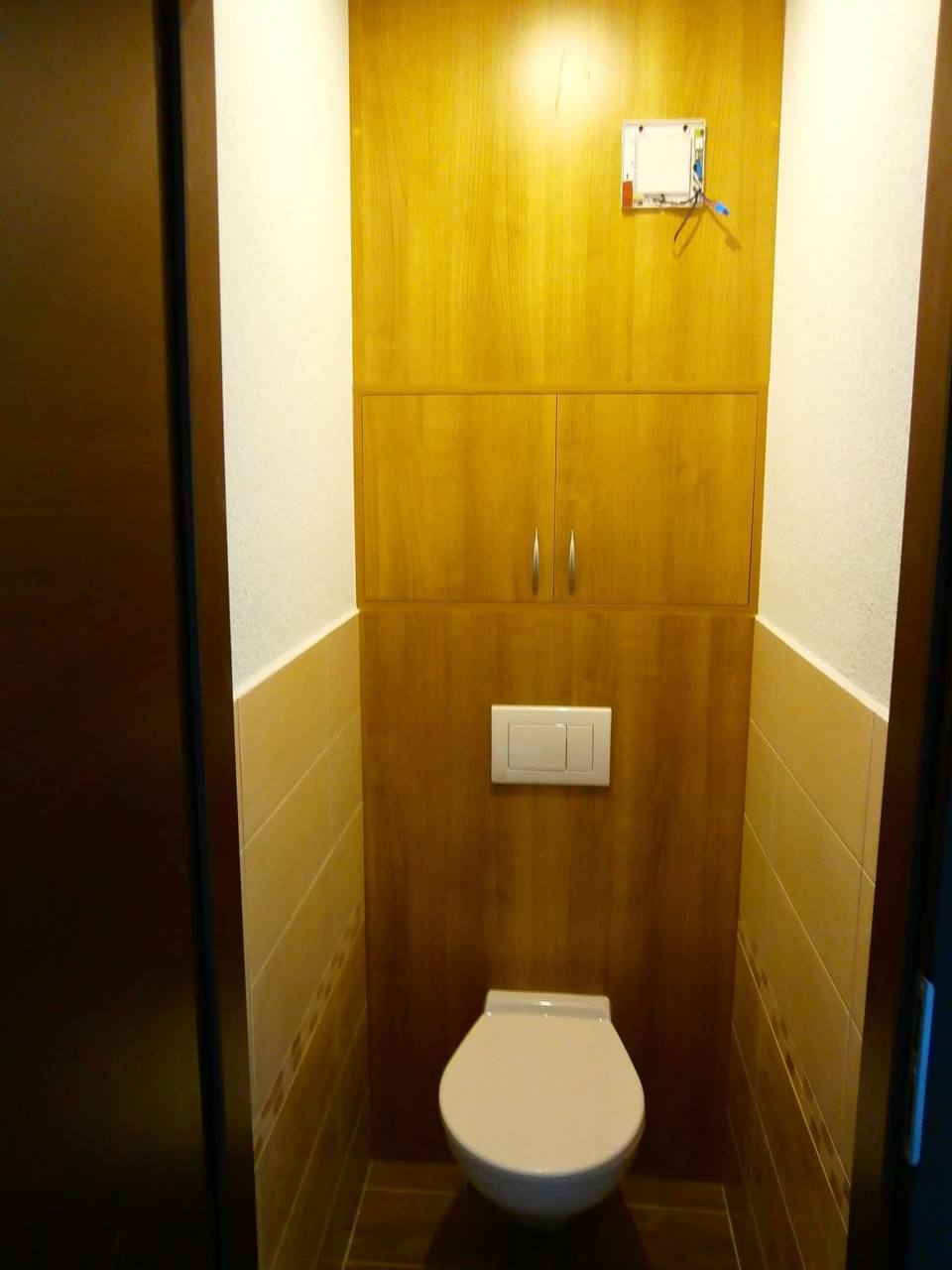 Schmales WC mit Schrank über der Toilette in Holzdekor