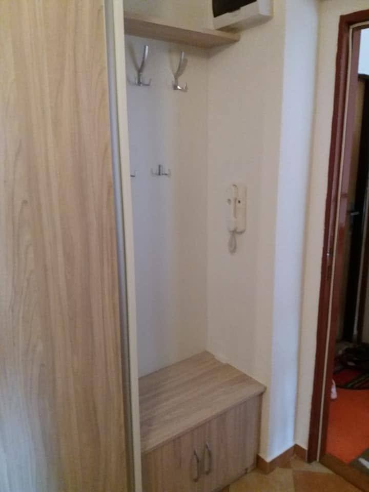 Schmale Nische mit Haken, Ablage und Sitzbank neben dem Schiebetürkasten
