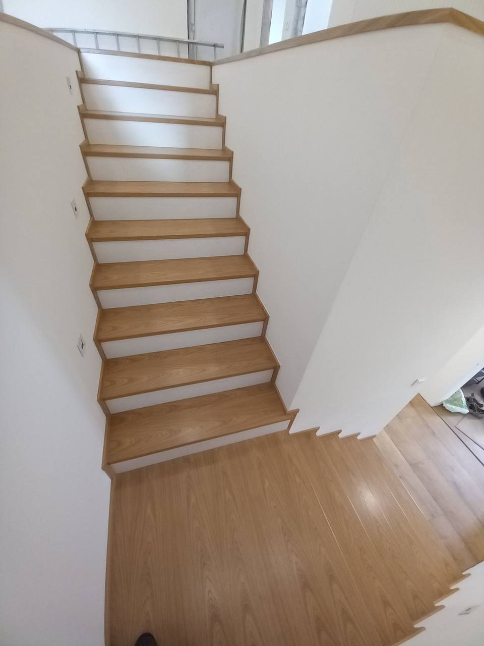 Lange Eichenstiege mit weißen Setzstufen von unten gesehen