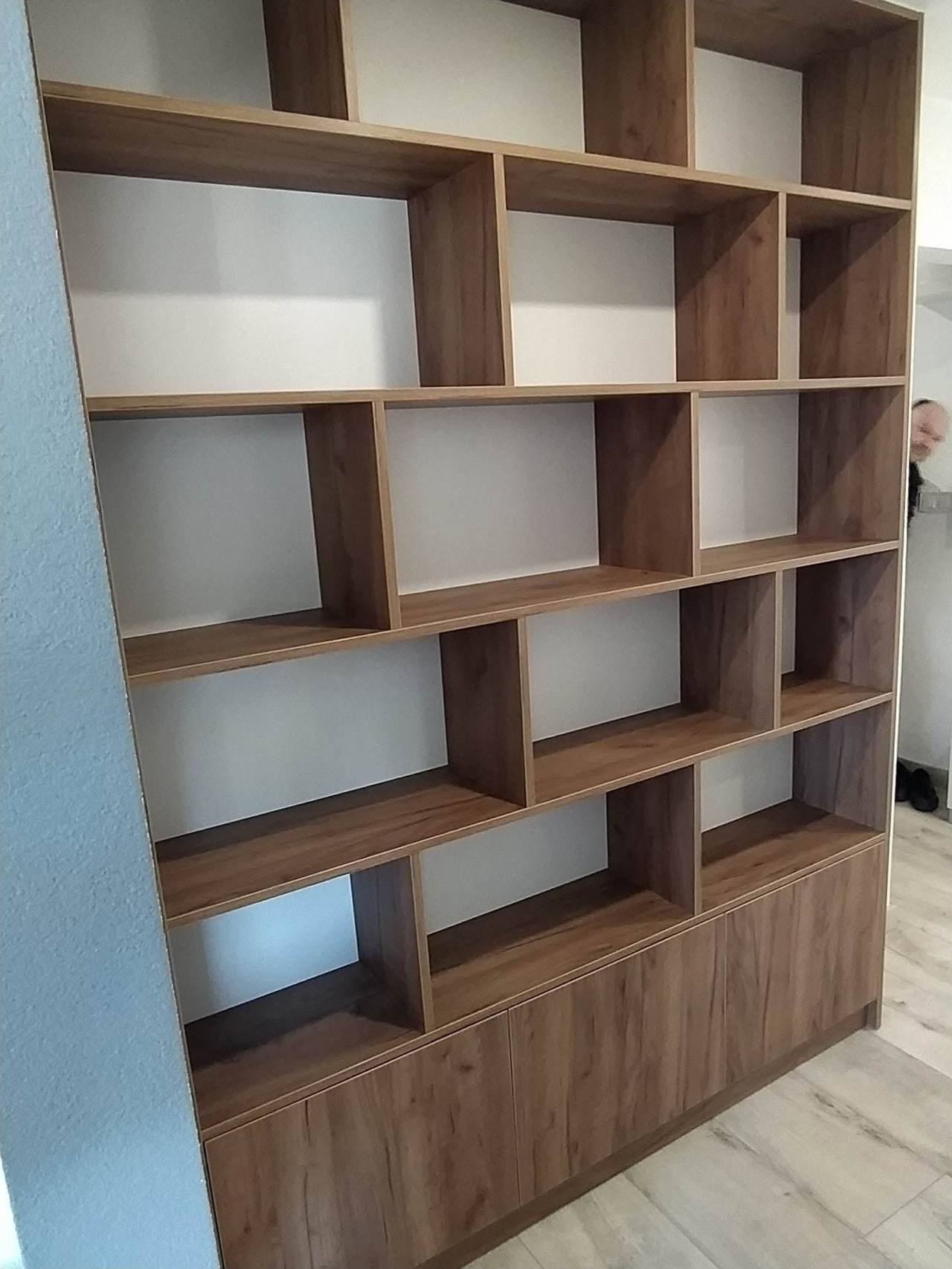 Bücherwand in Nussoptik mit versetzten Fächern und Unterkästen
