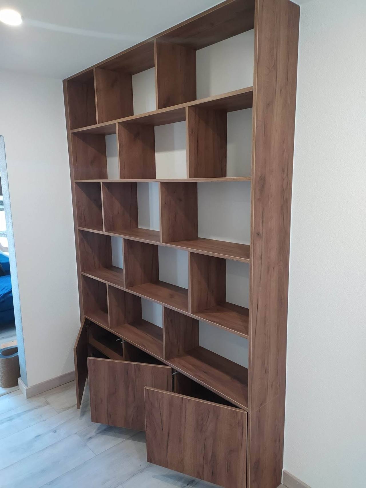 Bücherwand mit geöffneten Türen der Unterkästen