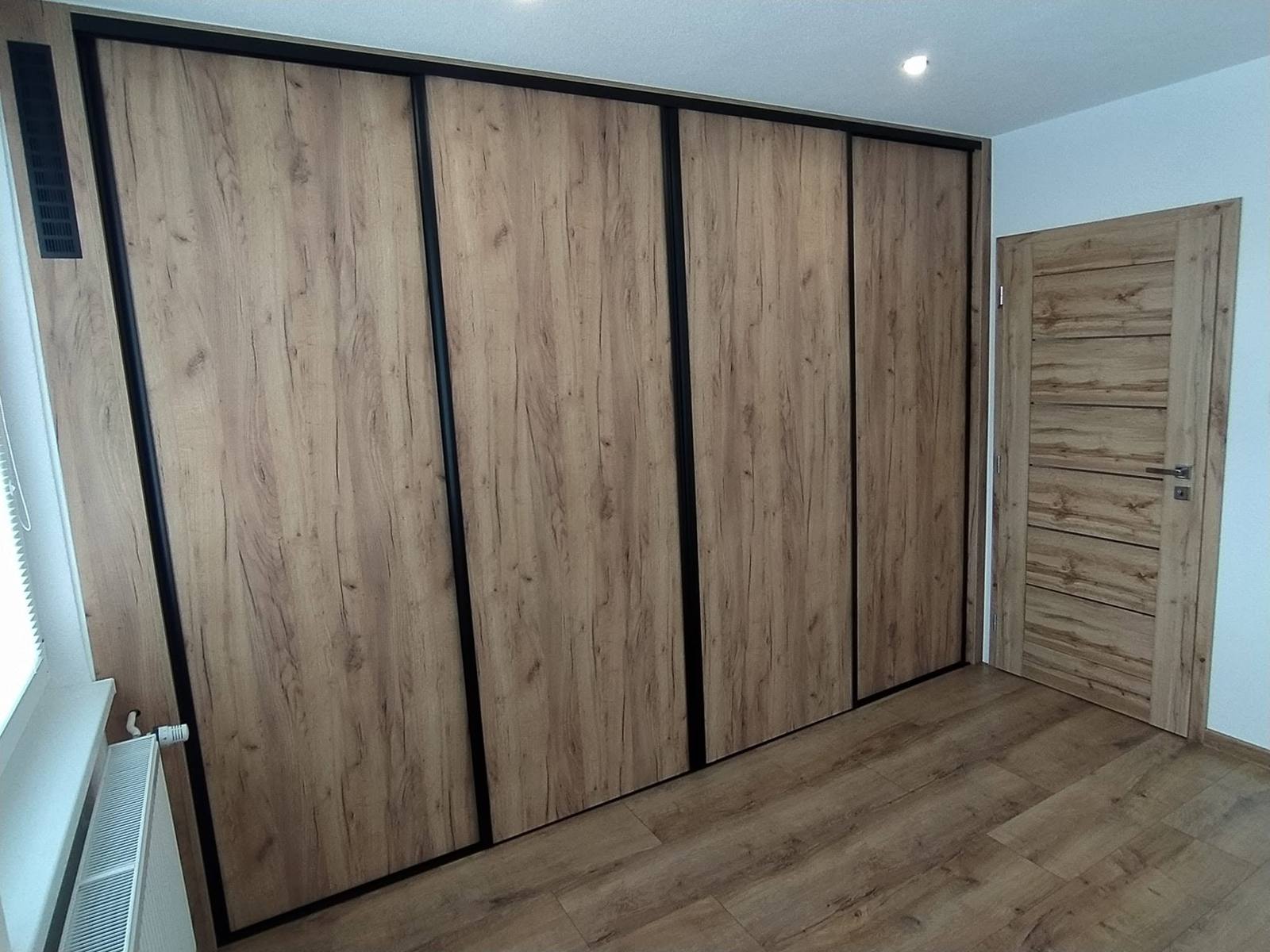 Viertüriger Schiebetürenkasten in Eichendekor über die ganze Schlafzimmerwand