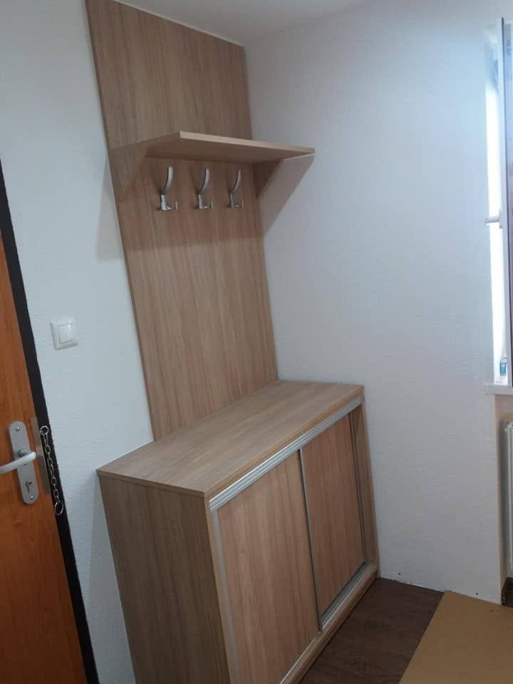 Garderobenboard mit drei Haken über einem niedrigen Kästchen in Eichendekor.