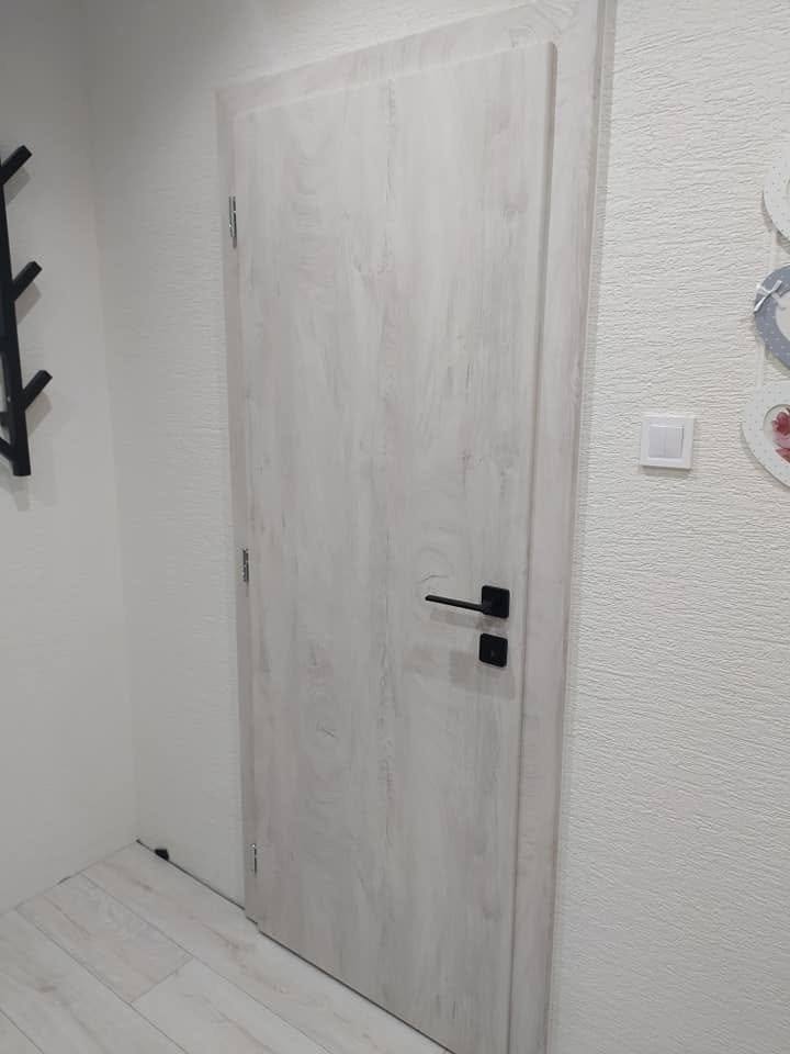 Hellgraue Tür an der Wand mit dekorativem Hänge-Herz
