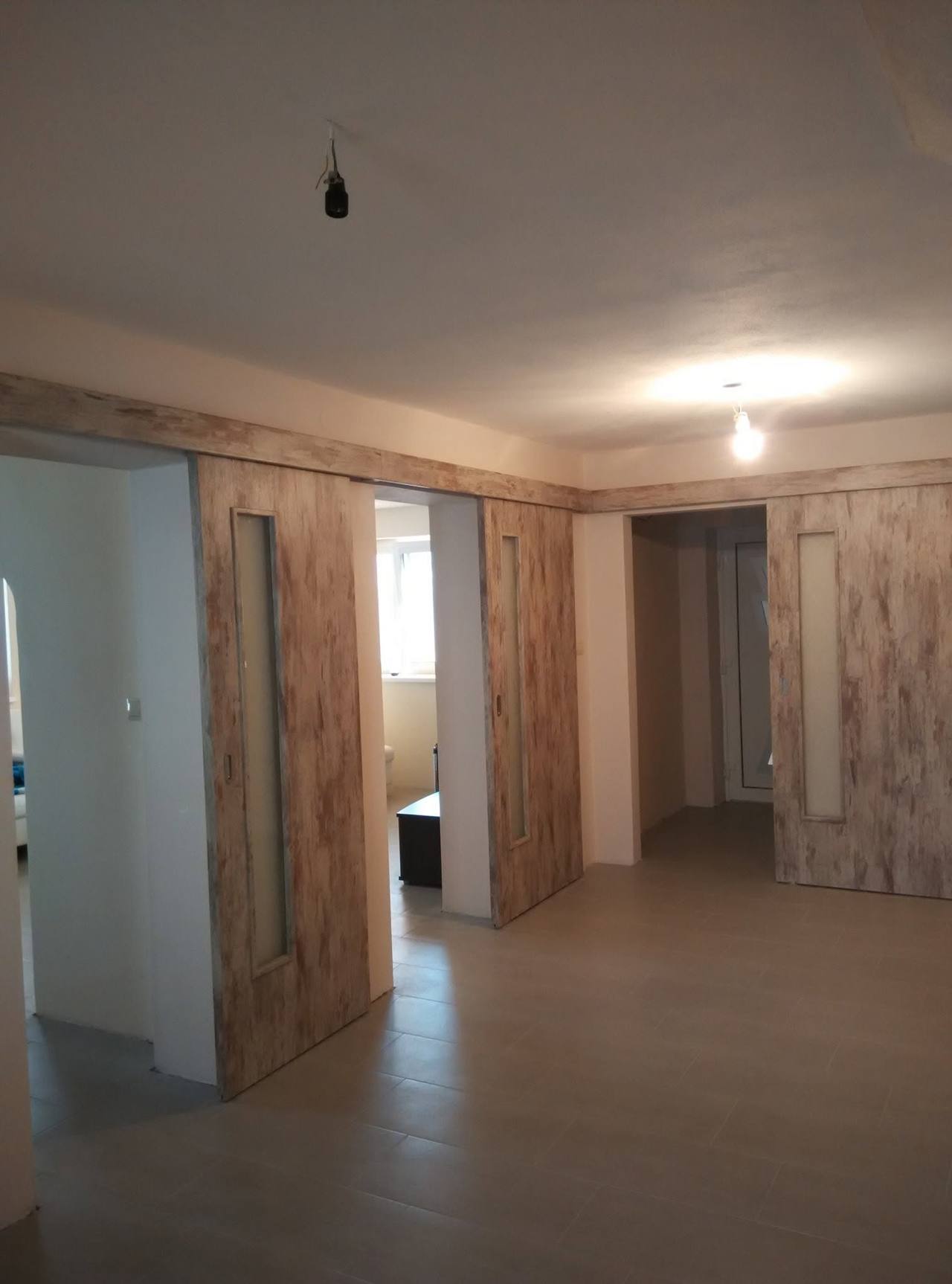 Otvorené posuvné dvere vo vintage dekore s drevenou lištou