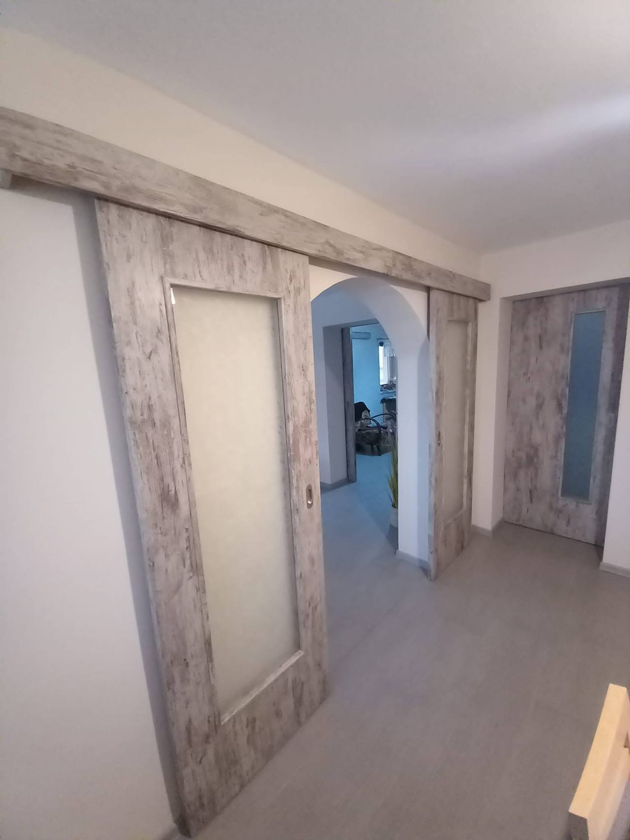 Otvorené posuvné dvere vo vintage dekore s pohľadom do izby