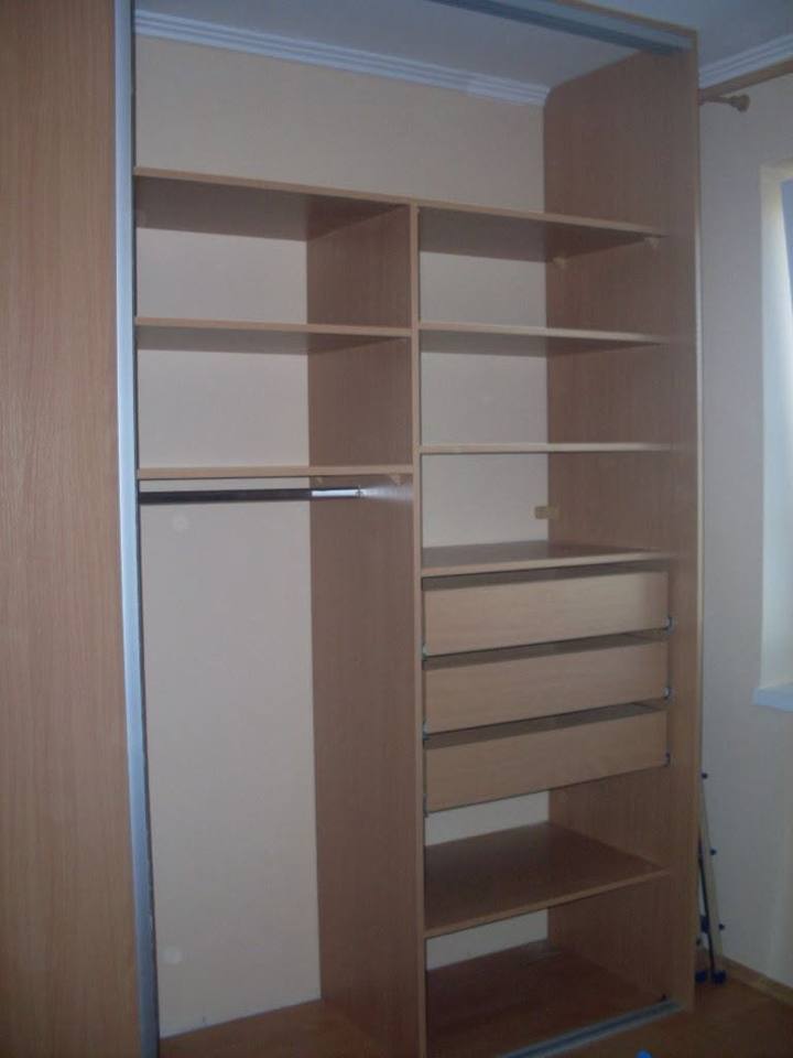 Innenausbau des Einbaukastens mit Fachböden, ausgezogenen Laden und Kleiderstange.