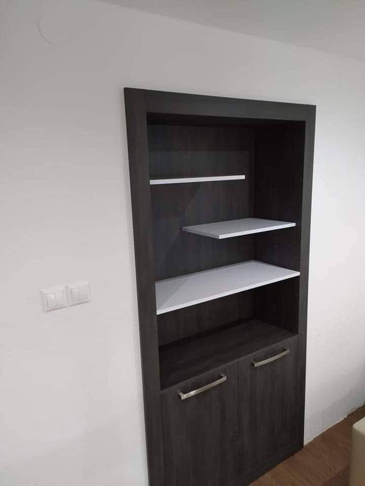 Einbauregal in dunkler Holzoptik mit weißen Borden