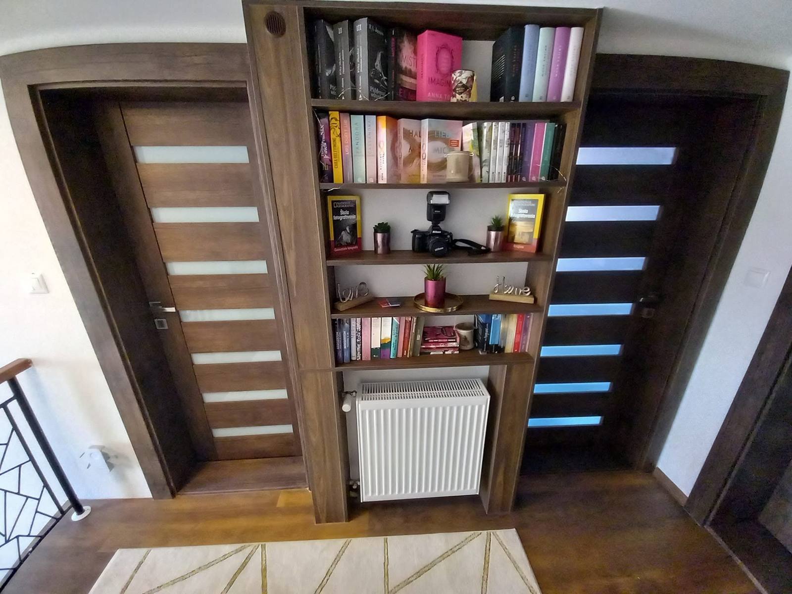 Bücherwand aus dunkler Eiche zwischen den Flurtüren eingebaut