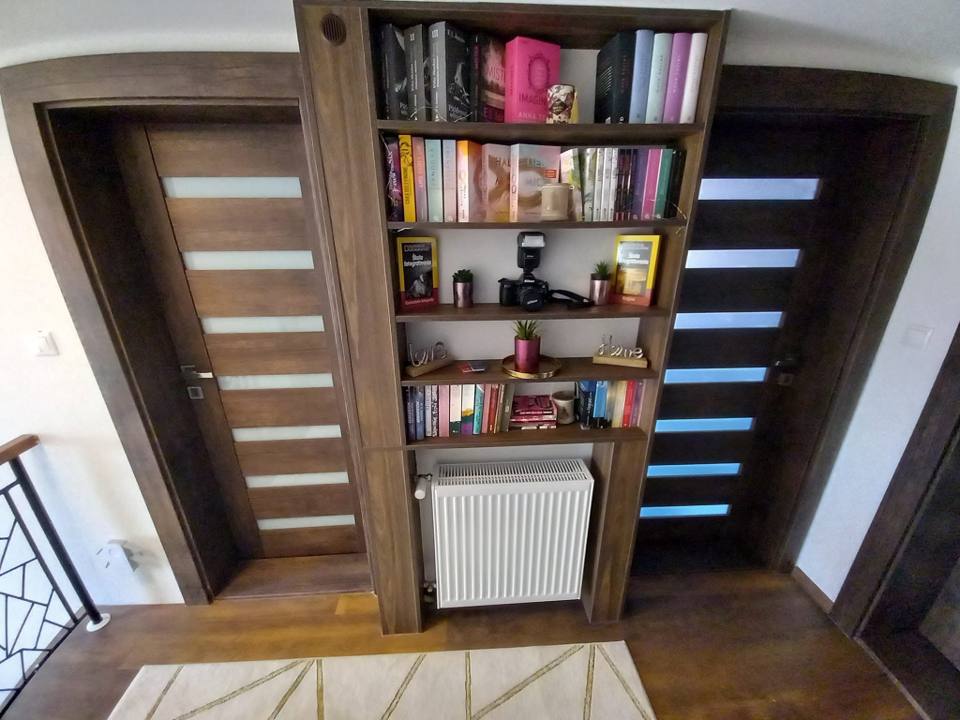Bücherwand aus dunkler Eiche zwischen den Flurtüren eingebaut