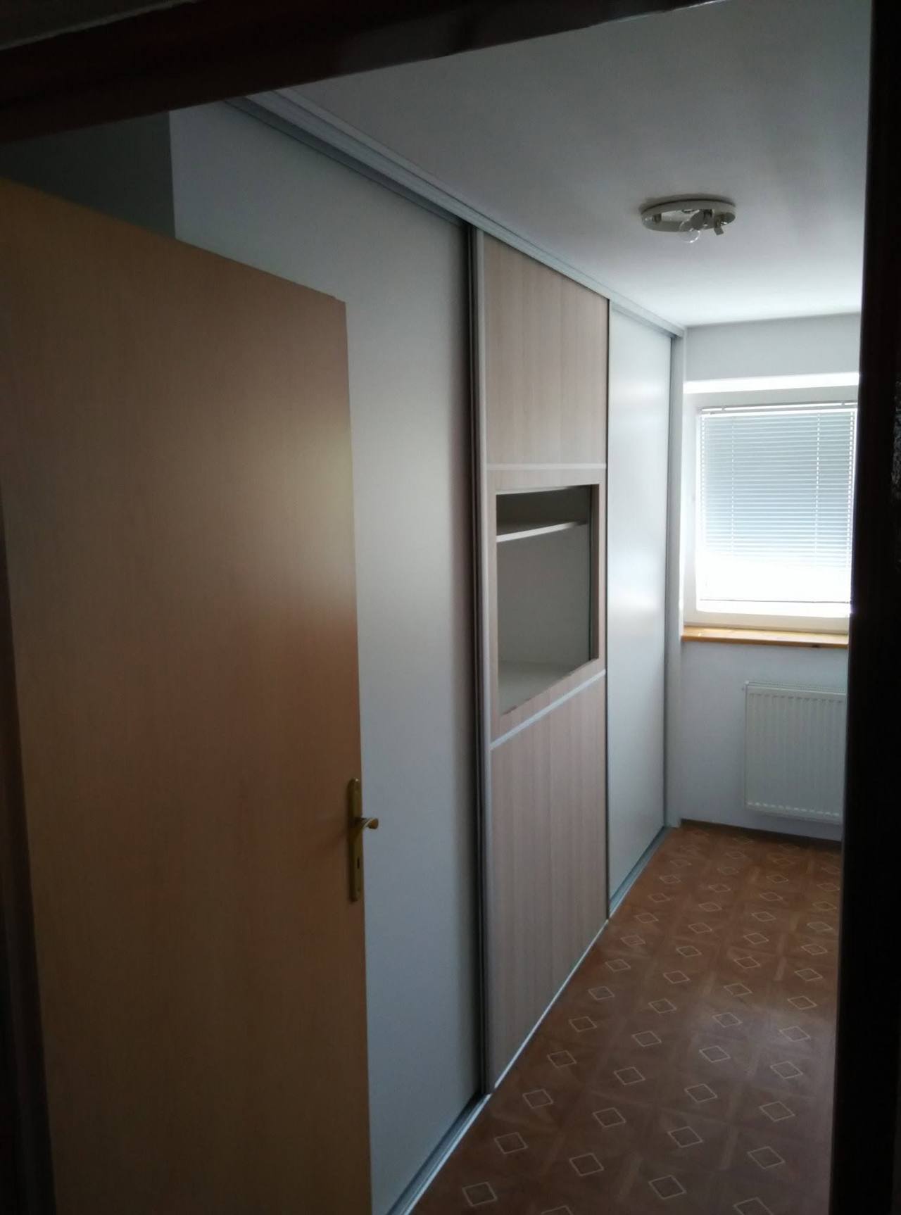 Vstavaná posuvná skriňa pozdĺž tmavej chodby