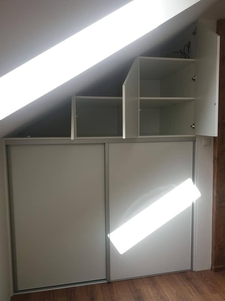 Kasten unter der Dachschräge mit Schiebetüren und einfallendem Licht.
