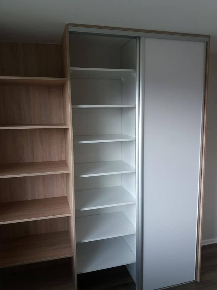 Einbaukasten mit offenem Regal in Weiß und Eiche sowie Schiebetüren.