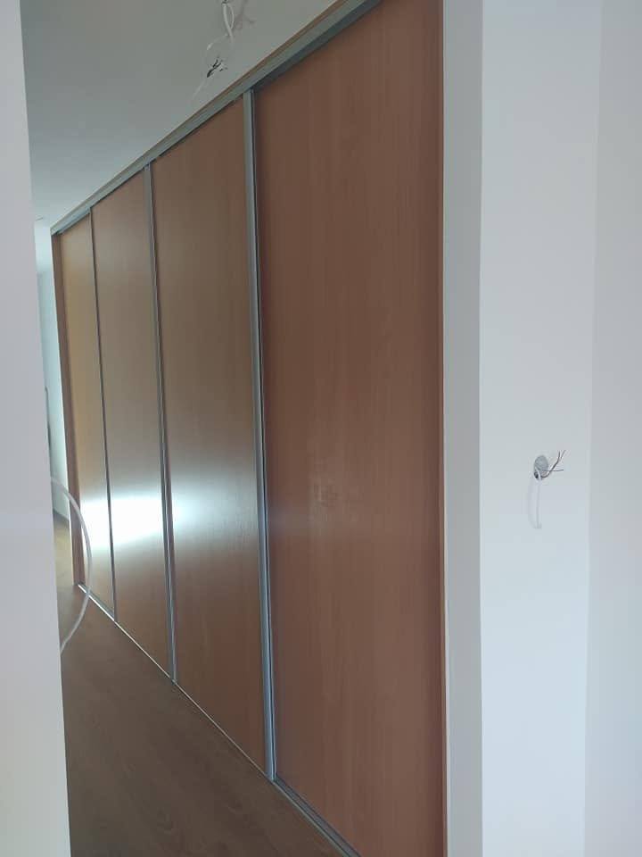 Einbaukasten mit Schiebetüren in Braunholzdekor im Flur.