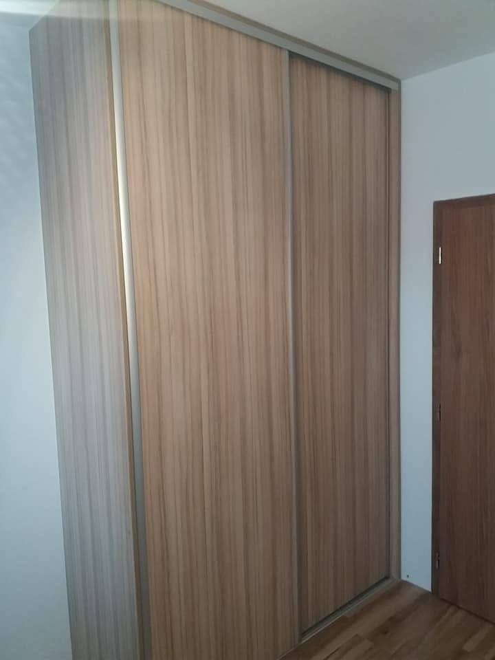 Einbaukasten mit Schiebetüren in Nussbaumton an der Zimmertür.